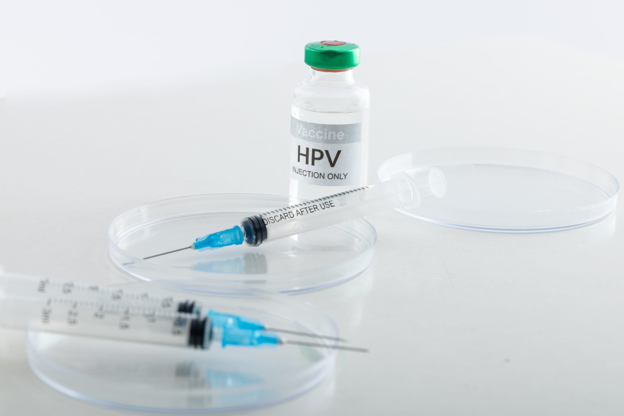 Composition of hpv vaccine vial and syringes on white background with copy space